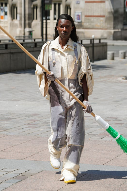 A model cleaning a street in Paris in Schueller De Waal overalls that resemble a uniform 