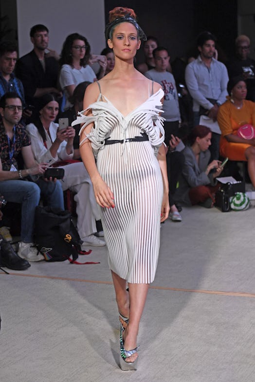 A model walking the runway in a white, striped, sheer Floral Miranda dress 