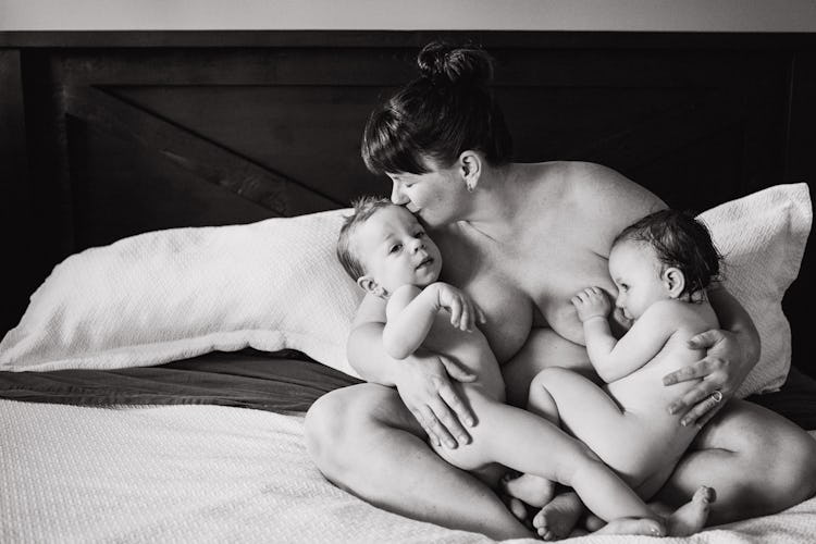 black and white photo of mom breastfeeding twins 