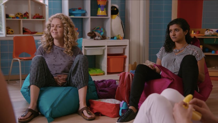 Two moms from Kate's mommy and me class in Workin' Moms Season 2 sitting on bean bag chairs 