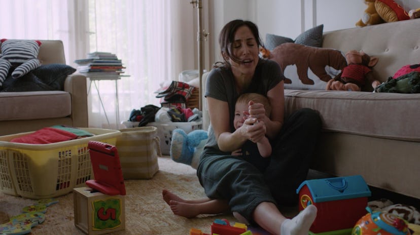 Kate in Workin' Moms Season 2 with her baby on the floor of her living room 