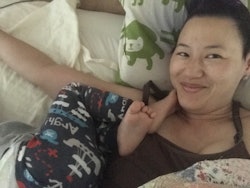 A mother taking a selfie while in bed with her child