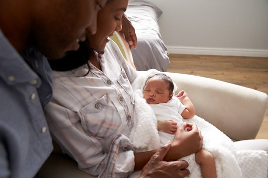 A mom and dad hold their newborn baby. 