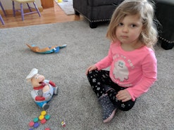 Lisa Kerslake's toddler daughter sitting on the floor and playing with her toys