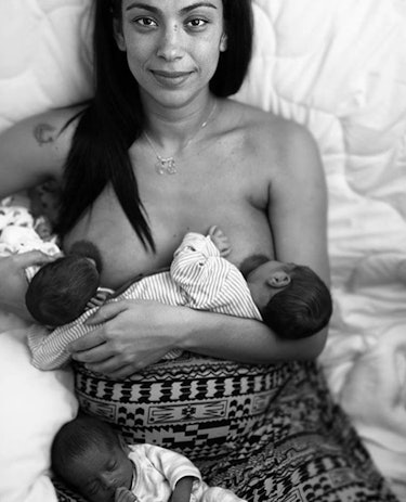 mom tandem breastfeeding twins while lying in bed