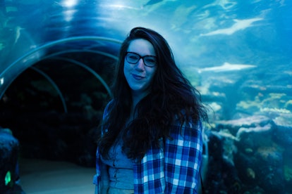 George Demetriades wearing a checked shirt, a crop top and glasses while visiting aquarium