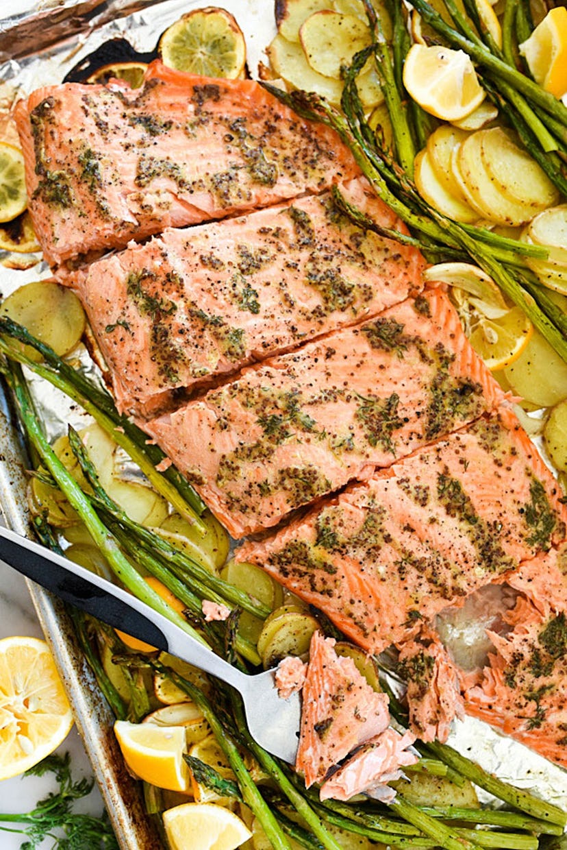 image of gluten free sheet pan mustard salmon, cooked over shaved potatos and asparagus