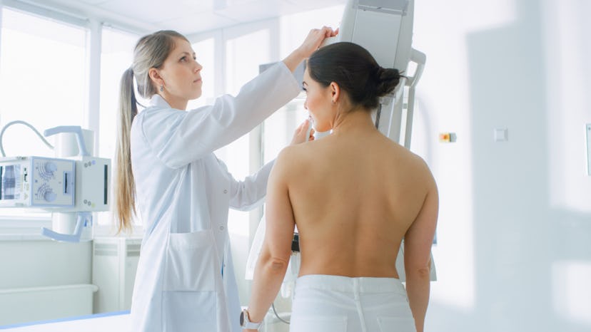 A woman experiencing nipple changes a less-common symptoms of breast cancer is having a check up at ...