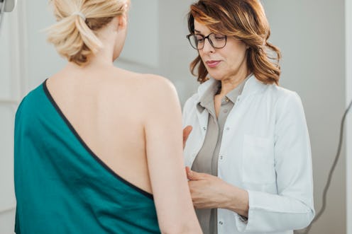 A doctor checking a woman because she has experienced less-common symptoms of breast cancer