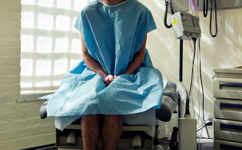 A young person diagnosed with colorectal cancer wearing a hospital gown while sitting in a bed.