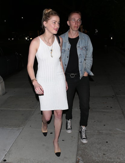 Amber Heard in a white dress and black pumps walking down the street