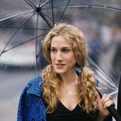 Sarah Jessica Parker as Carrie Bradshaw walking under an umbrella