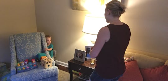 Child hiding behind the chair to poop while his mom looks at him