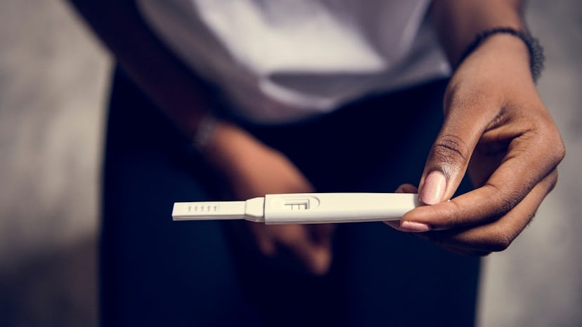 a woman looking at a pregnancy test