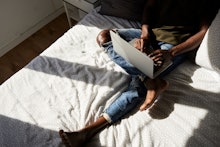 A person on their laptop in bed working from home 