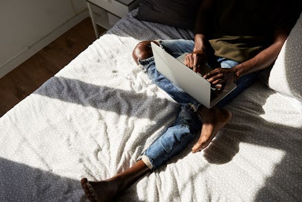 A person on their laptop in bed working from home