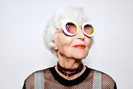 An optimistic old woman wearing white circle-shaped sunglasses