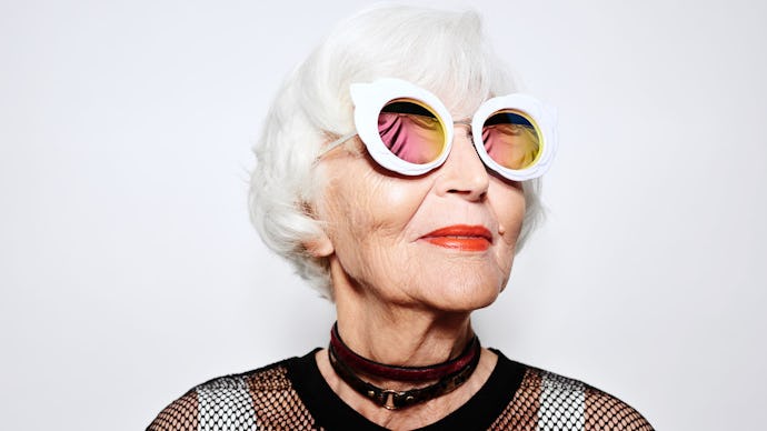 An optimistic old woman wearing white circle-shaped sunglasses