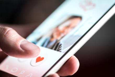 A person holding a smartphone, and swiping on a dating app