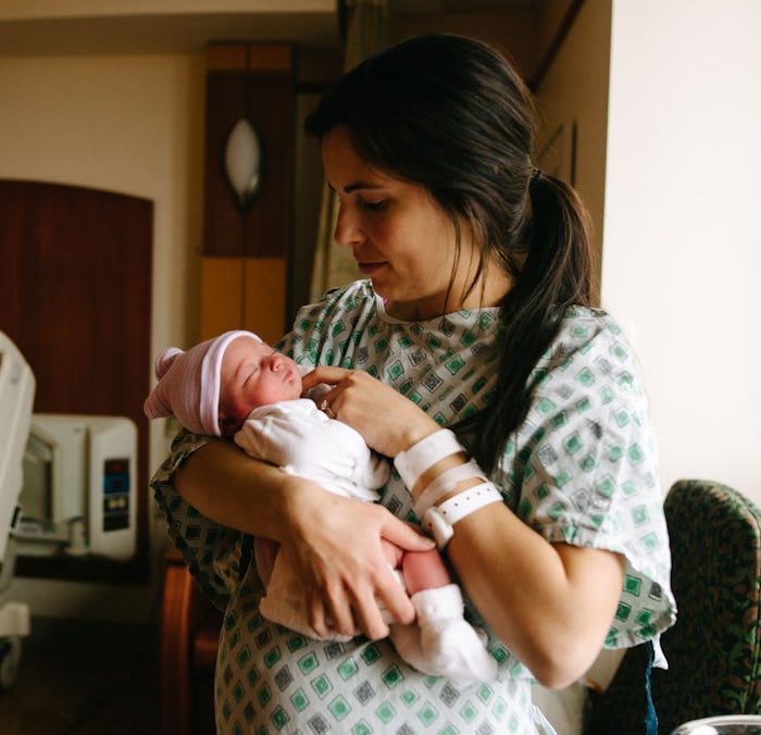 A mother holding her newborn baby in the hospital