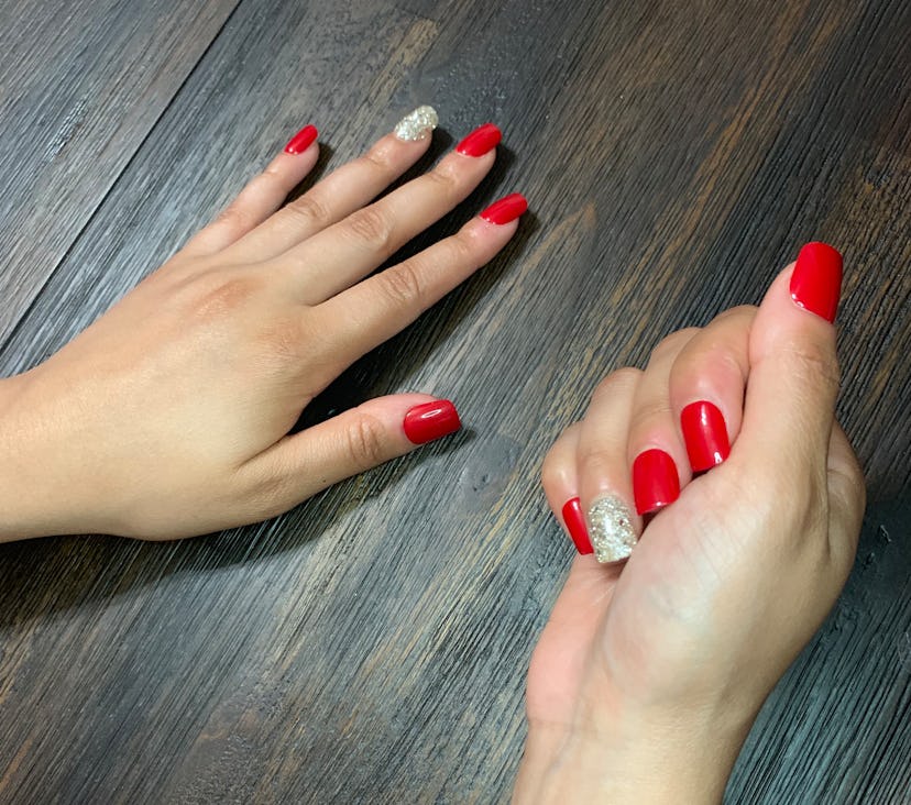 Hands with red and silver shimmery press-on nails 