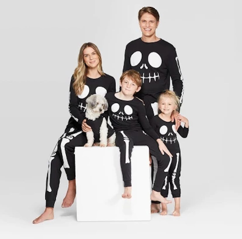 A family in Target's matching black skeleton Halloween pajamas