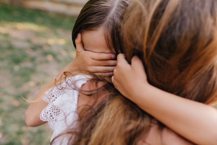 A little daughter hugging her mother and crying