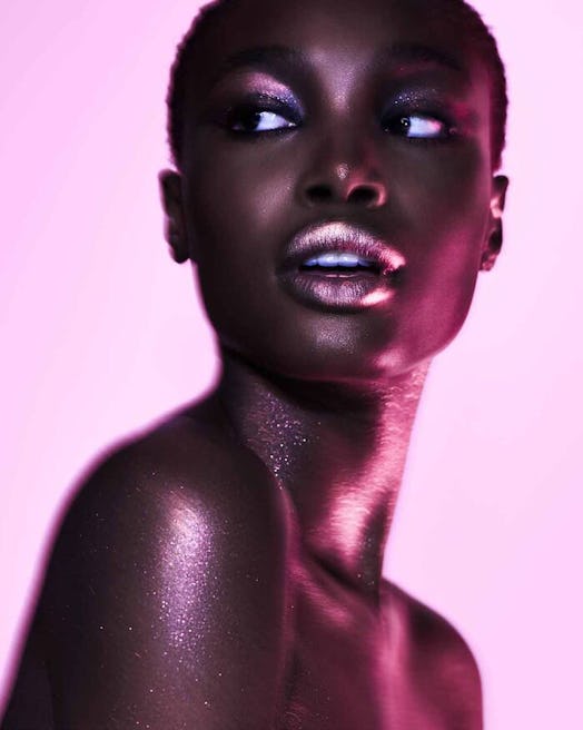 a model posing while using Fenty Beauty shiny products