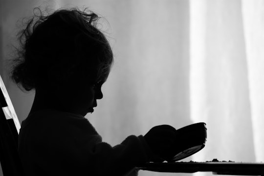 The shadow of a toddler eating from a plate, with a picky eating habit