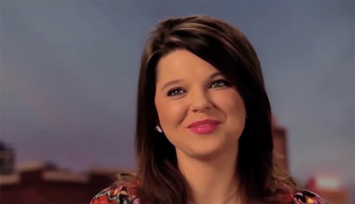 Amy Duggar after giving birth to her first child, smiling for a photo.