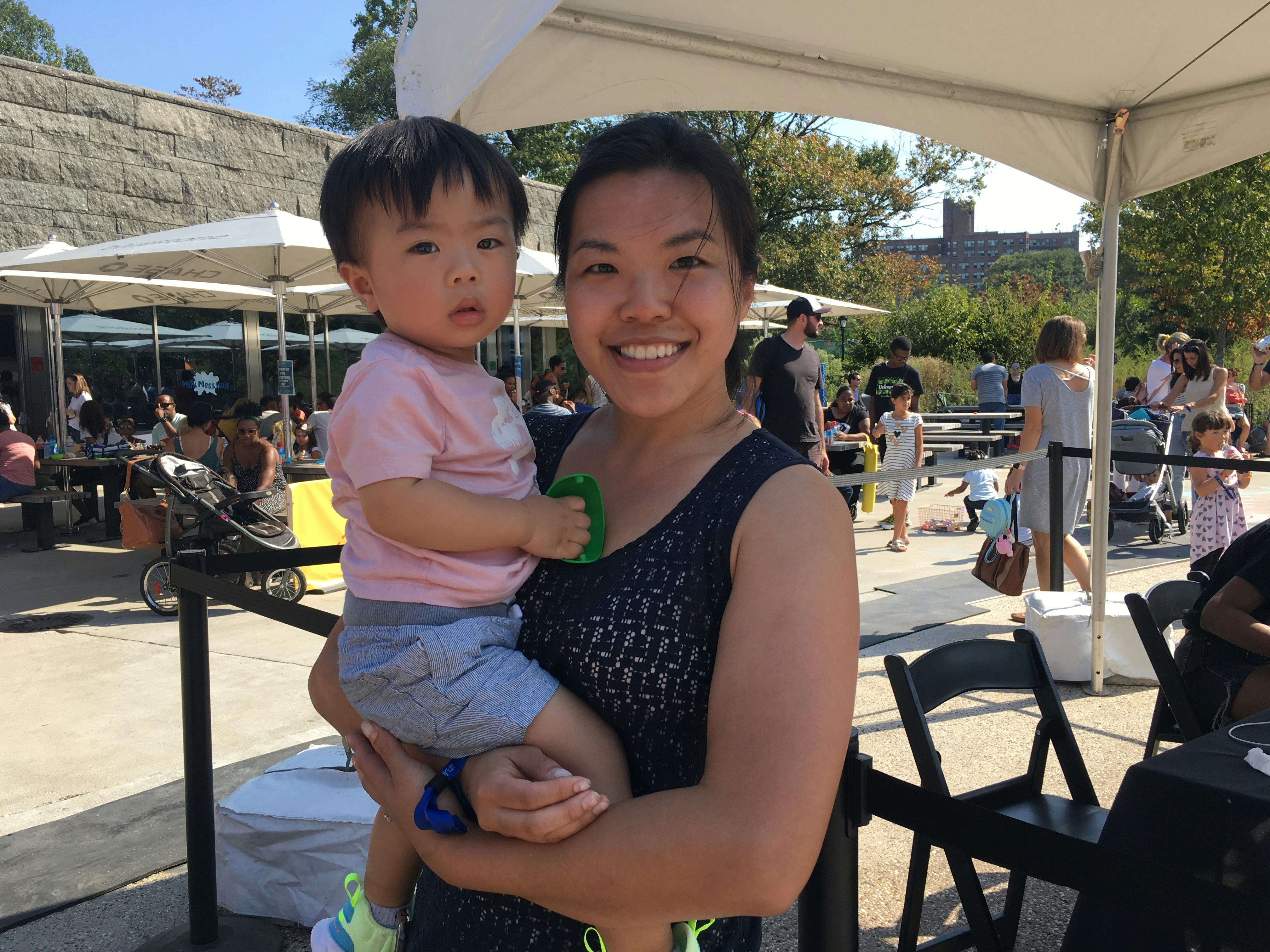 A mom smiling while holding her child at Camp Romper