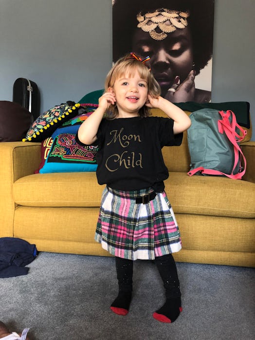 A little girl wearing a black shirt with "moon child" text