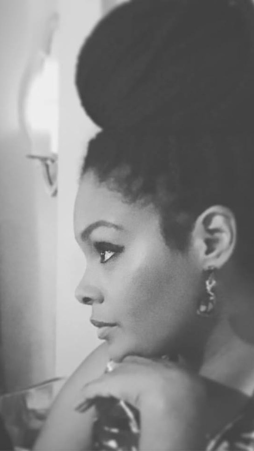 Vashti Harrison posing wearing a patterned dress with her hair in a bun looking off to the side