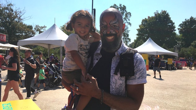 Jason, a dad with face paint on, holding his daughter 