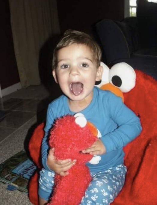 The little boy happily smiling and playing with his Elmo doll before his death