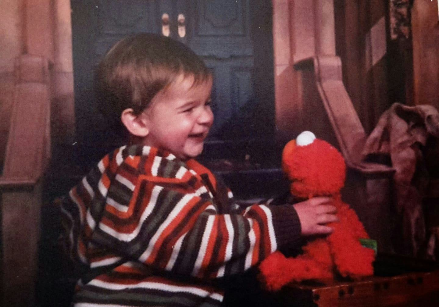 A little smiling son with an Elmo Doll before his death
