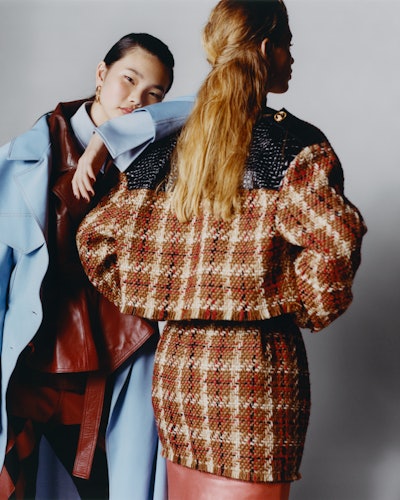 Two models wearing Ellery coat, jacket, shirt, pants; IPPOLITA earrings. Versace jacket, skirts. 