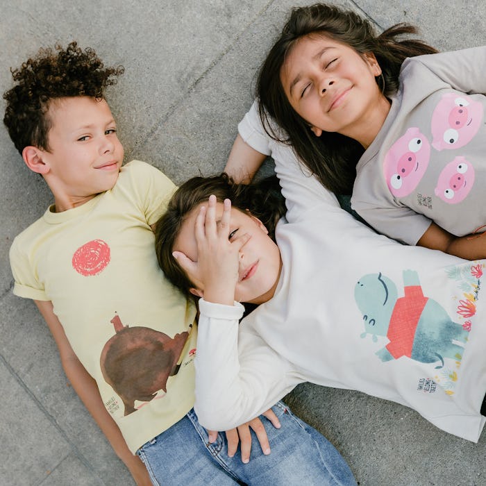 Three children posing in the Winter Water Factory x Families Belong Together capsule collection clo...
