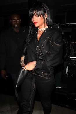 Rihanna in an all-black outfit with straight bangs and light curls