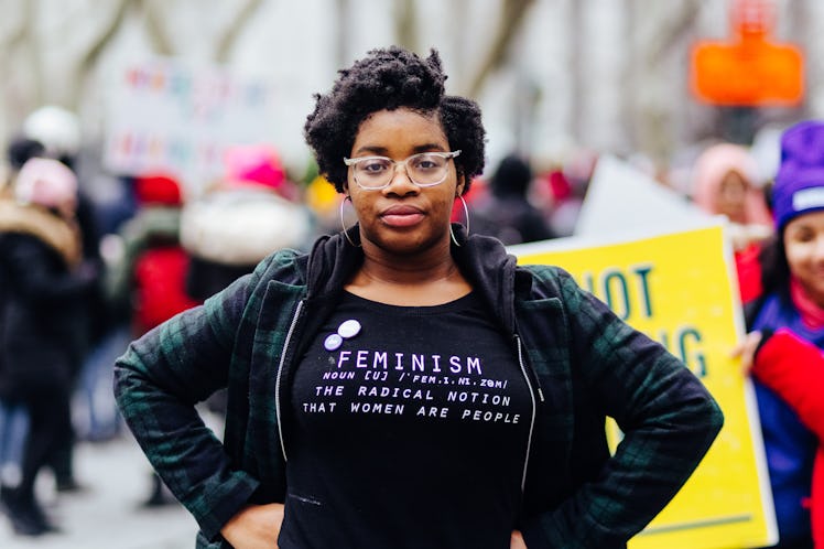 Alliyah Logan posing for a photo on protests with a shirt with "feminism" text on it 