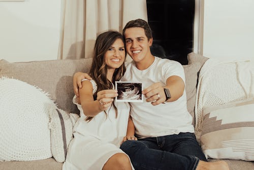 Carlin Bates with her partner showing an ultrasound picture