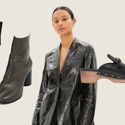 A model in a black mylar blazer surrounded by an asymmetrical bodysuit, calfskin tabi boots, and lea...