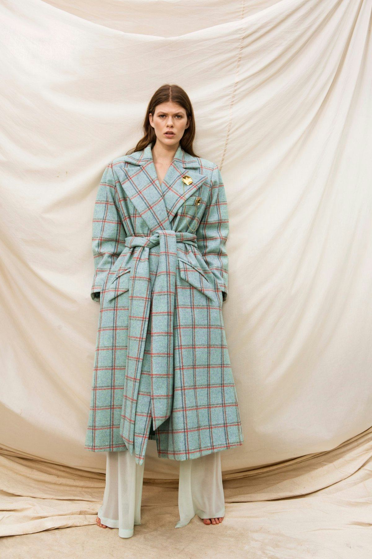 A model in a Here to Stay Coat by Maggie Marilyn and beige trousers