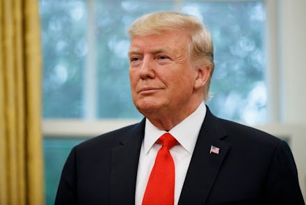 Donald Trump in a black suit, white shirt, and a red tie