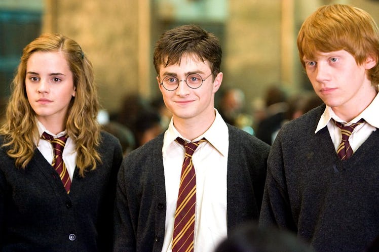 Hermione, Harry, and Ron from 'Harry Potter' stand together in the Great Hall.