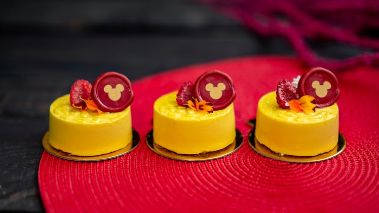 Three Disney Lunar New Year mango pineapple pastries with a Mickey Mouse decoration sit on a table. 
