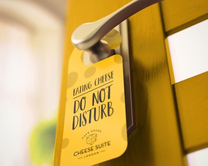 A 'Do Not Disturb' sign hangs on the yellow door of the Cheese Suite by Café Rouge.
