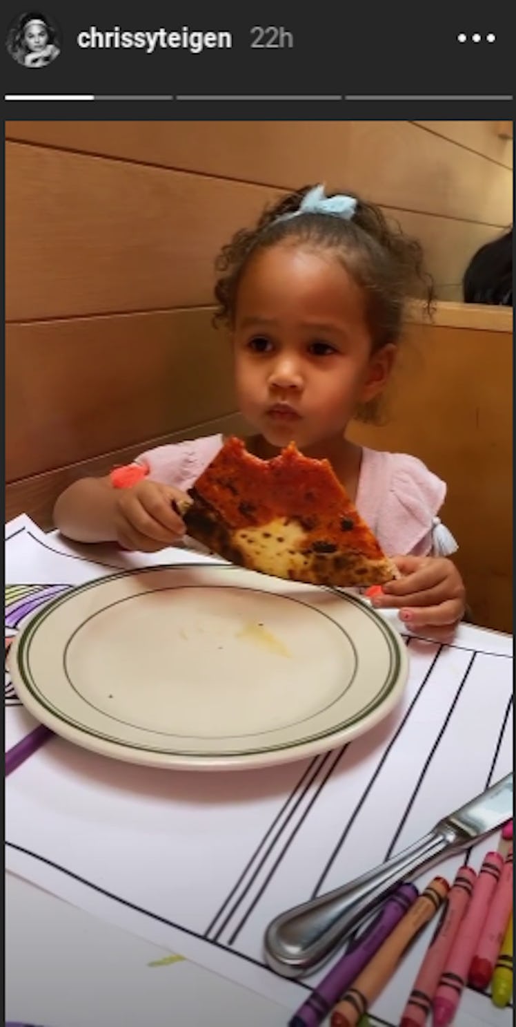 Chrissy Teigen and Luna eating pizza