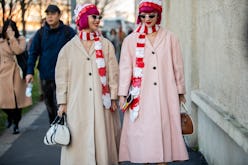 Two women in coats and matching hats and scarves in red-white as cold-weather accessories