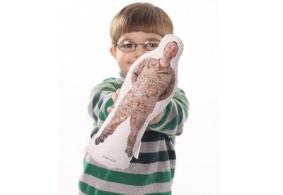 a little boy holding a hug-a-hero doll